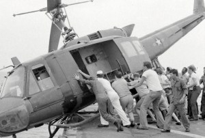 Crew members push a helicopter off a landing platform of the U.S.S. Kirk to clear room for more helicopters dropping off refugees. Photo courtesy Craig Compiano/USS Kirk Association.