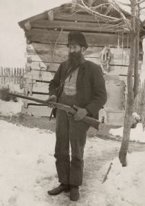 Rifle ready William Anderson "Devil Anse" Hatfield stands in the snow outside a cabin, circa 1890's. Photo courtesy of West Virginia and Regional History Center, WVU Libraries.